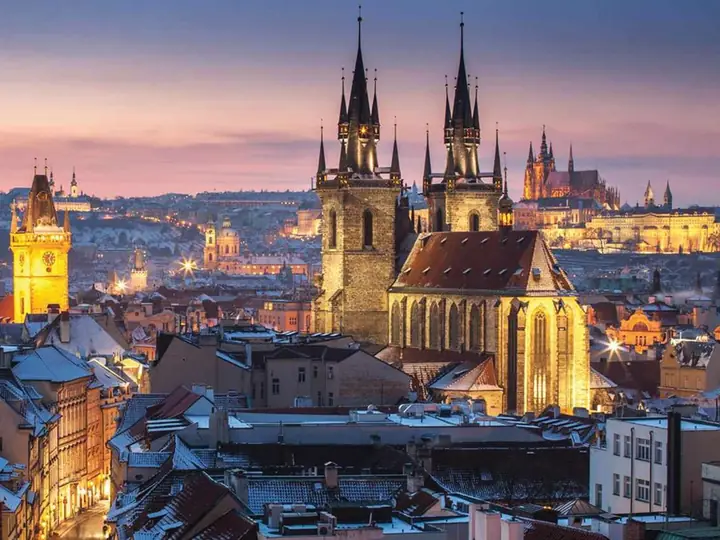 Prague Old Town rooftops and church spires at dusk