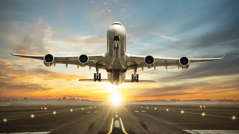 Passenger aircraft taking off from a runway at sunset